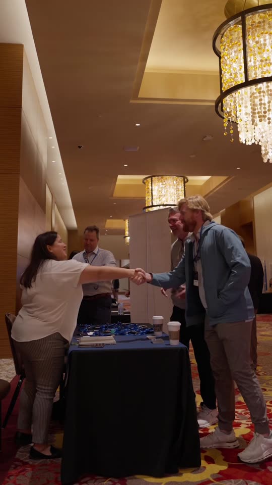 An agent greeting a vendor partner at a registration table